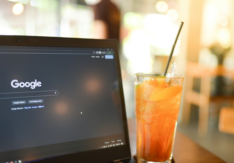 Laptop và ly trà đào trên bàn quán cà phê ở TP. Hồ Chí Minh
