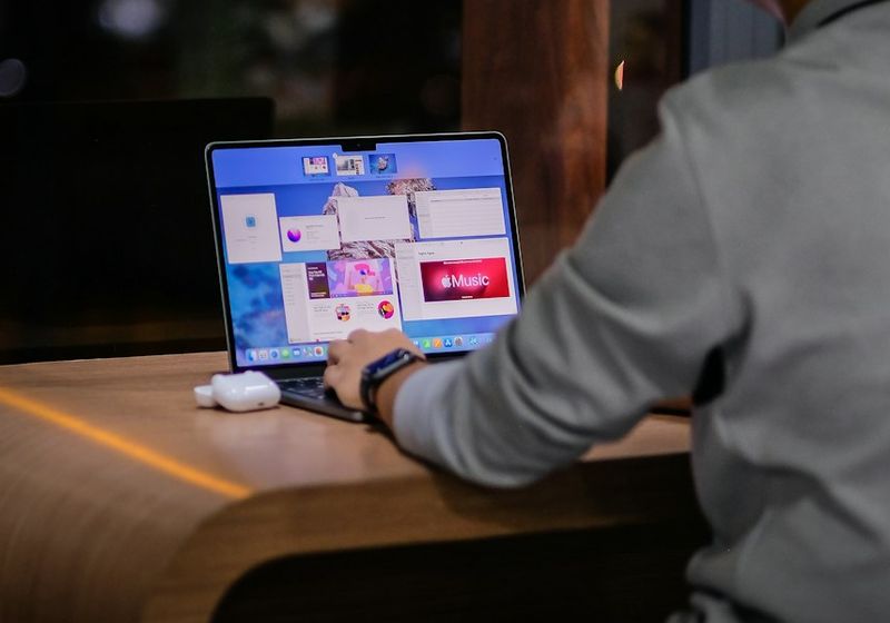 Người làm việc với laptop trong quán cà phê ở TP. Hồ Chí Minh, nhìn từ sau lưng
